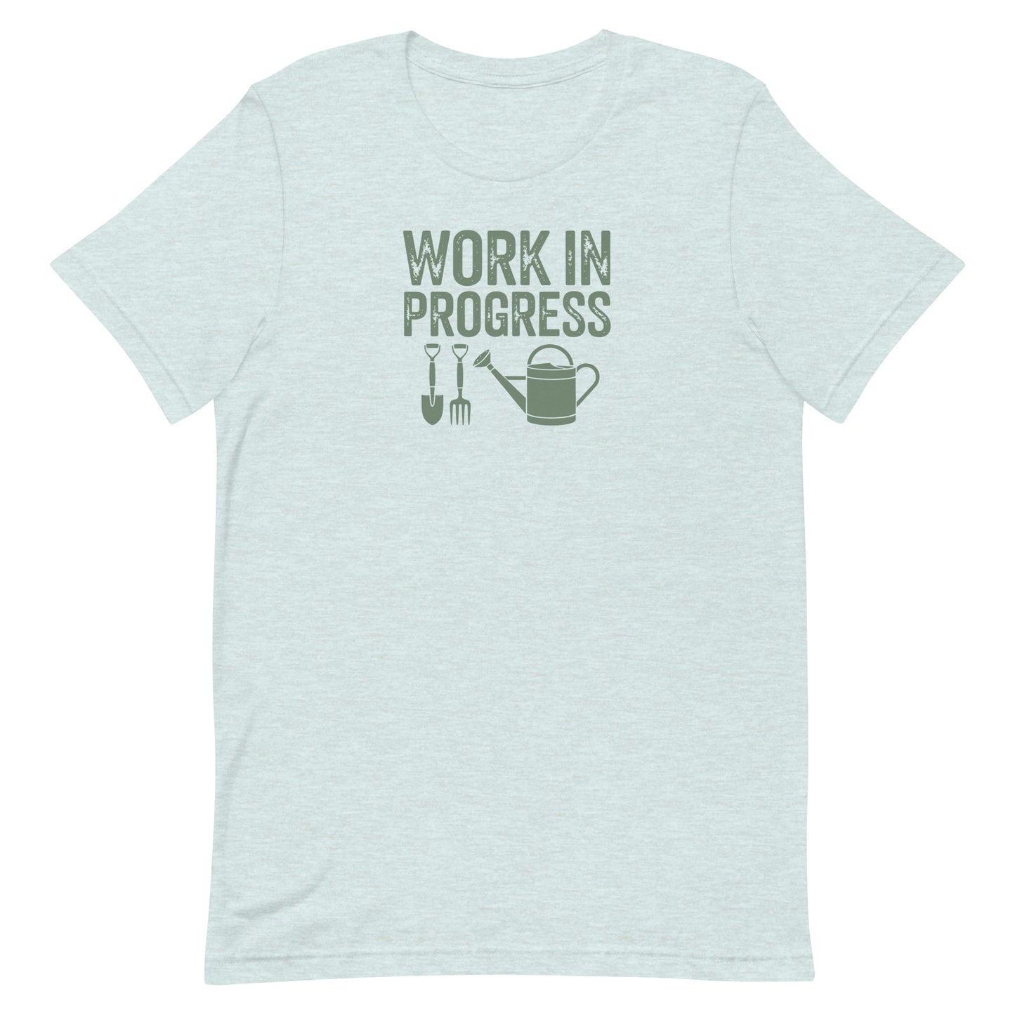 “Work in Progress” gardening graphic with shovel, pitchfork, and watering can printed in sage green on a soft heather ice blue colored crewneck t-shirt.