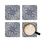 Four blue and white patterned coasters with a cup of coffee on one coaster.