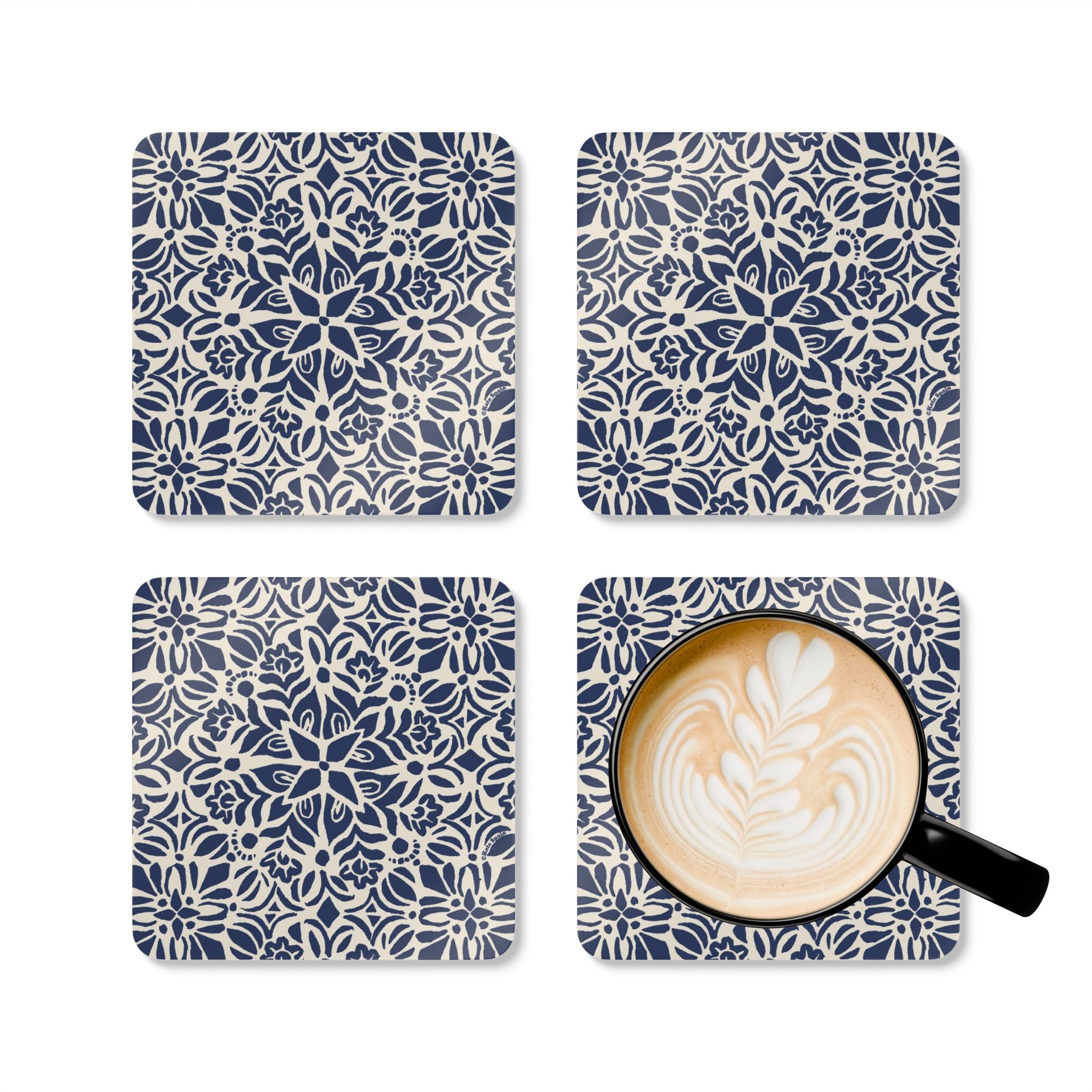 Four blue and white patterned coasters with a cup of coffee on one coaster.