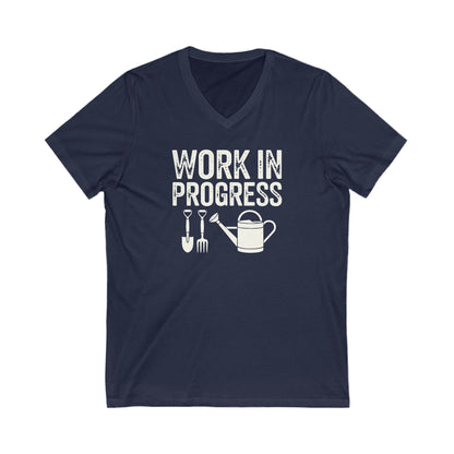 Navy Blue colored vneck t-shirt with white words that say 'Work in Progress' in distressed style text. Below the words are graphic images of gardening tools including a shovel, pitchfork and watering can.