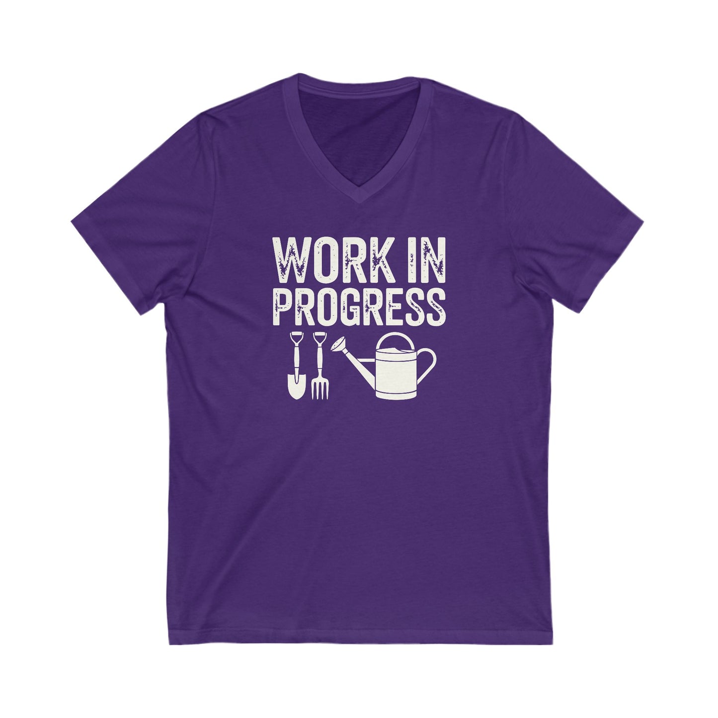 Rich purple colored vneck t-shirt with white words that say 'Work in Progress' in distressed style text. Below the words are graphic images of gardening tools including a shovel, pitchfork and watering can.