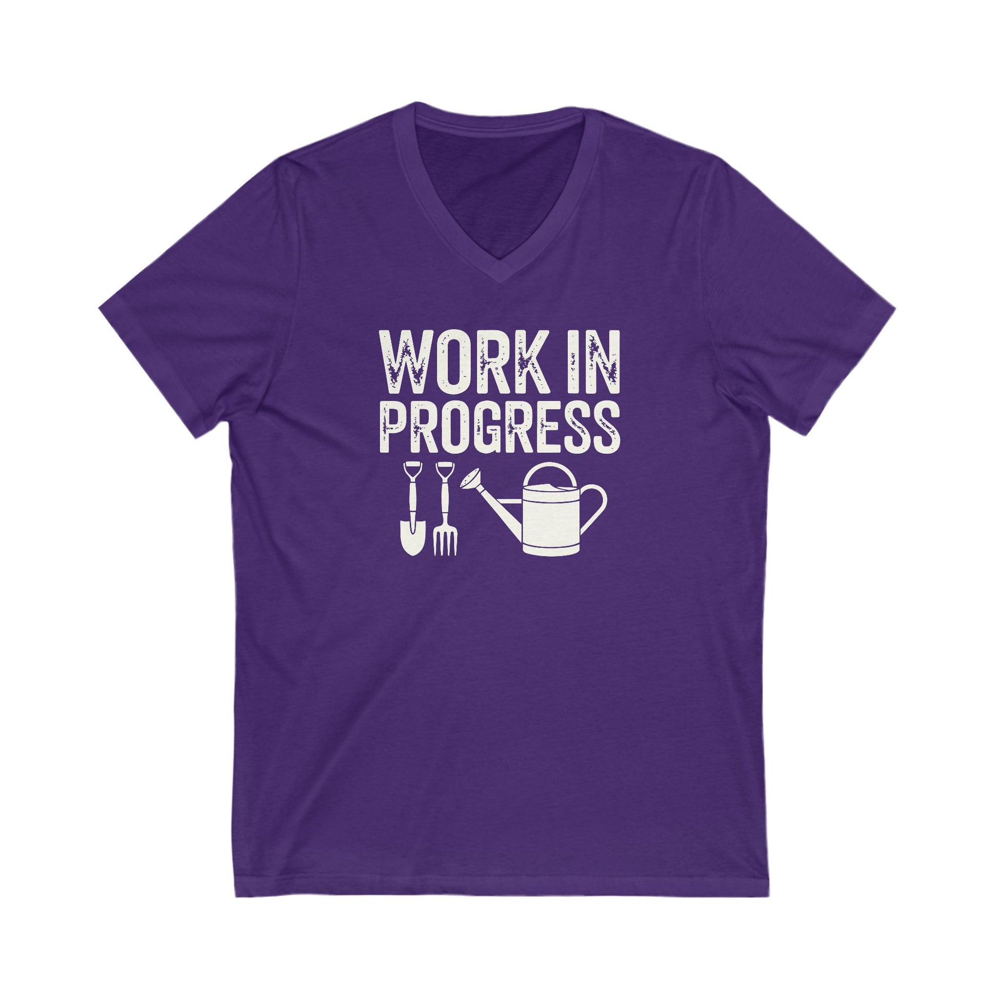Rich purple colored vneck t-shirt with white words that say 'Work in Progress' in distressed style text. Below the words are graphic images of gardening tools including a shovel, pitchfork and watering can.