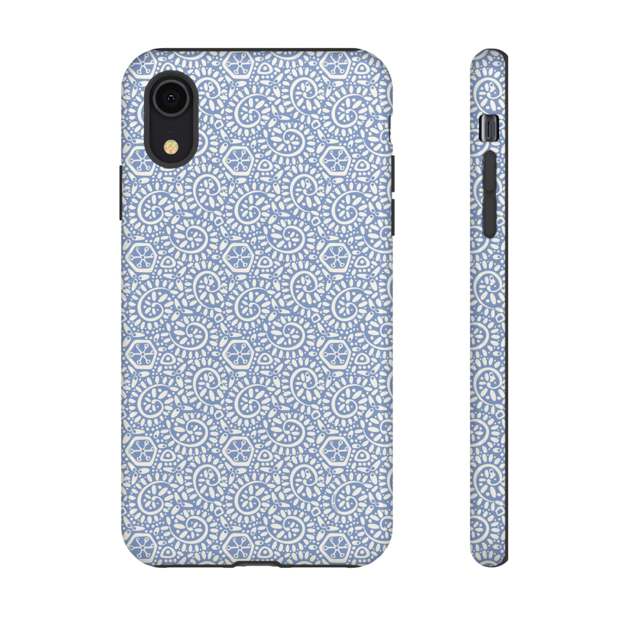 Canto Swirls Mist iPhone XR Glossy Case — periwinkle blue hard case covered in an intricate folk-art medallion pattern of radiating white circular motifs, dot clusters, and geometric centers