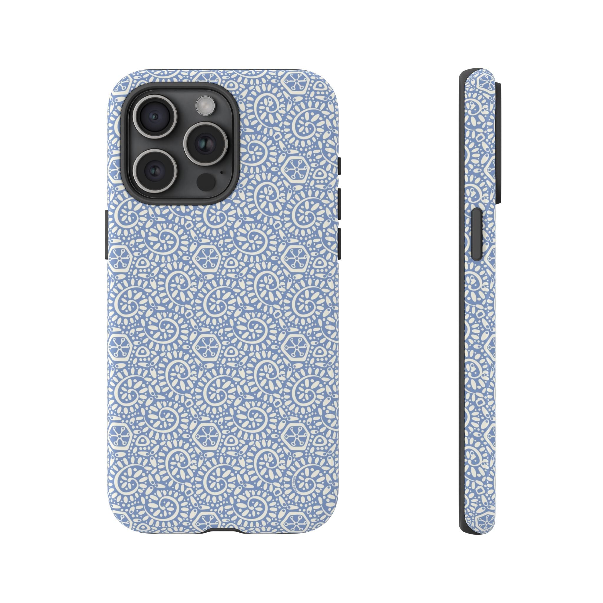 Canto Swirls Mist iPhone 15 Pro Max Glossy Case — periwinkle blue hard case covered in an intricate folk-art medallion pattern of radiating white circular motifs, dot clusters, and geometric centers
