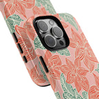 Hibiscus Coral iPhone 16 Pro Max Glossy Case — angled view showing slim profile; blush pink case with coral red hibiscus flowers and teal-green leaves in bold botanical linework