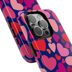 Hearts Tough iPhone 16 Pro Max Case – lifestyle/angled shot | navy, pink, red, coral scattered heart print