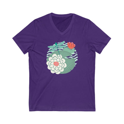 Illustrated dragonfly hovering over a green lily pad with pink and white water lily flowers on a calm pond, printed on a soft saturated purple vneck t-shirt.