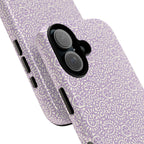 Canto Swirls Lavender iPhone 17 Glossy Case — angled view showing slim profile; lavender folk-art medallion pattern of radiating circular motifs, dot clusters, and geometric centers