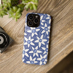 Starflower iPhone 16 Pro Max Tough Case lifestyle shot including phone case on phone on desk of grainy wood with a potted succulent plant.