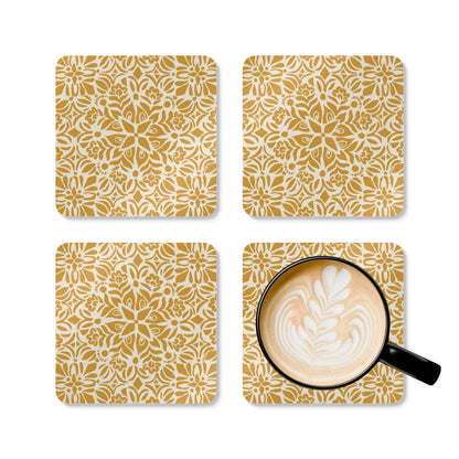Four gold and white patterned coasters with a cup of coffee on one coaster.