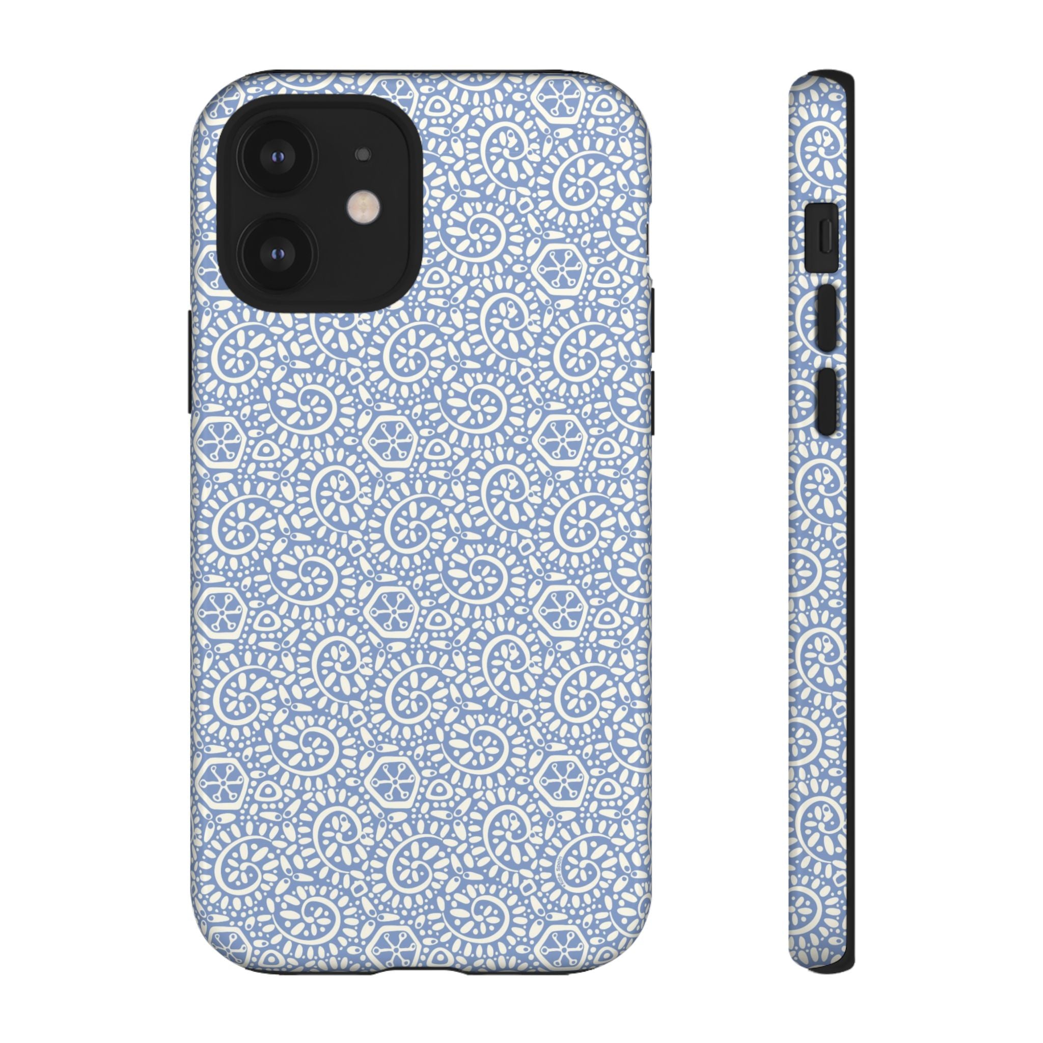 Canto Swirls Mist iPhone 12 Glossy Case — periwinkle blue hard case covered in an intricate folk-art medallion pattern of radiating white circular motifs, dot clusters, and geometric centers