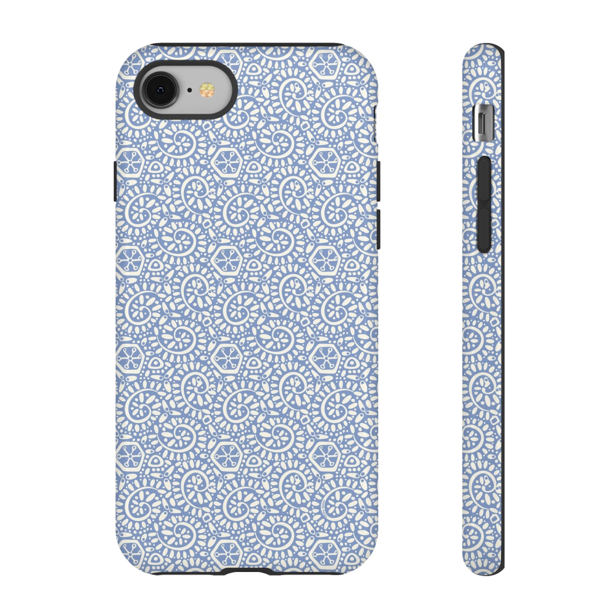 Canto Swirls Mist iPhone 8 Glossy Case — periwinkle blue hard case covered in an intricate folk-art medallion pattern of radiating white circular motifs, dot clusters, and geometric centers