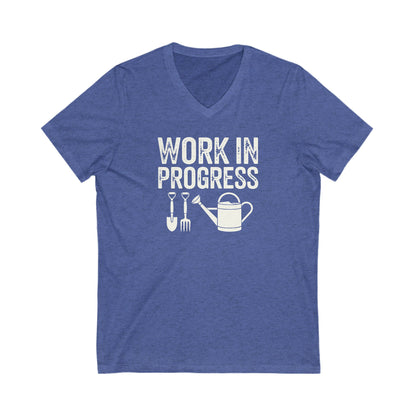 Heather Royal Blue colored vneck t-shirt with white words that say 'Work in Progress' in distressed style text. Below the words are graphic images of gardening tools including a shovel, pitchfork and watering can.
