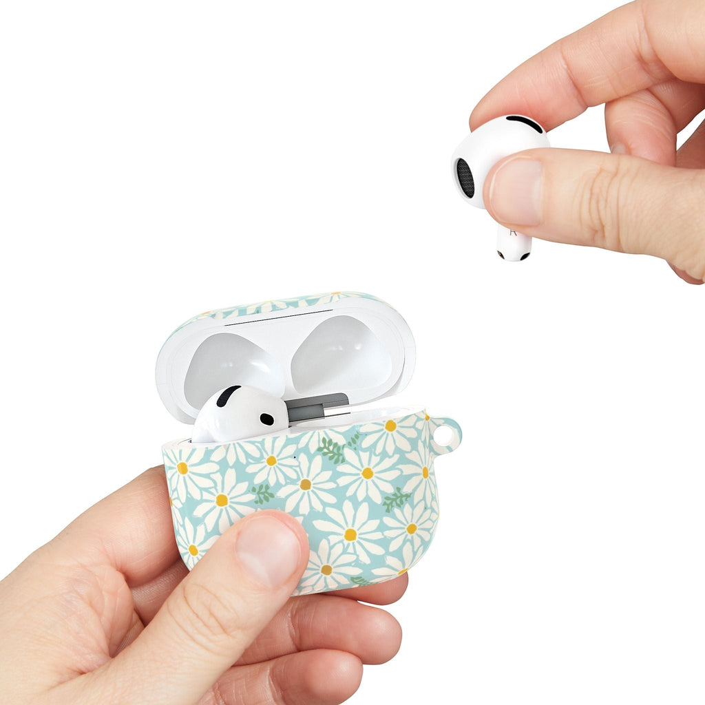floriori Daisies AirPods case featuring summer white daisies with yellow centers on an aqua background with green leaves printed on glossy polycarbonate shell. Shows scale of case.
