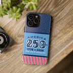 Sea to Shining Sea Tough iPhone 16 Pro Case on wood-grained desk. Case is navy, sky blue, red, white American stars & stripes 250th anniversary print