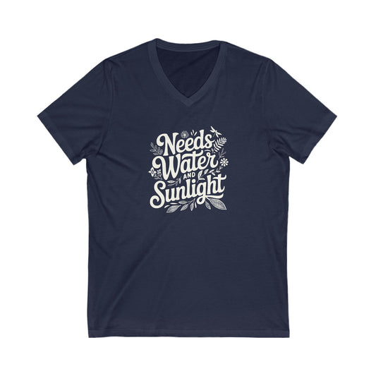 Navy Blue colored vneck t-shirt with white words that say 'Needs Water and Sunlight' in script style text with dragonfly, flower and leaf illustrations around the words.