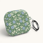 AirPods Gen 4 case – Glossy | periwinkle and cream ditsy flowers on sage green ground — angled view with keychain ring on case