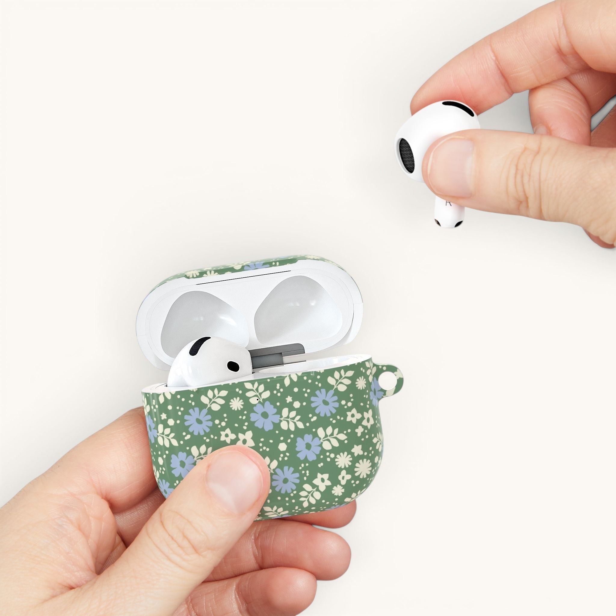 AirPods Gen 4 case, hand holding case – Glossy | periwinkle and cream ditsy flowers on sage green ground