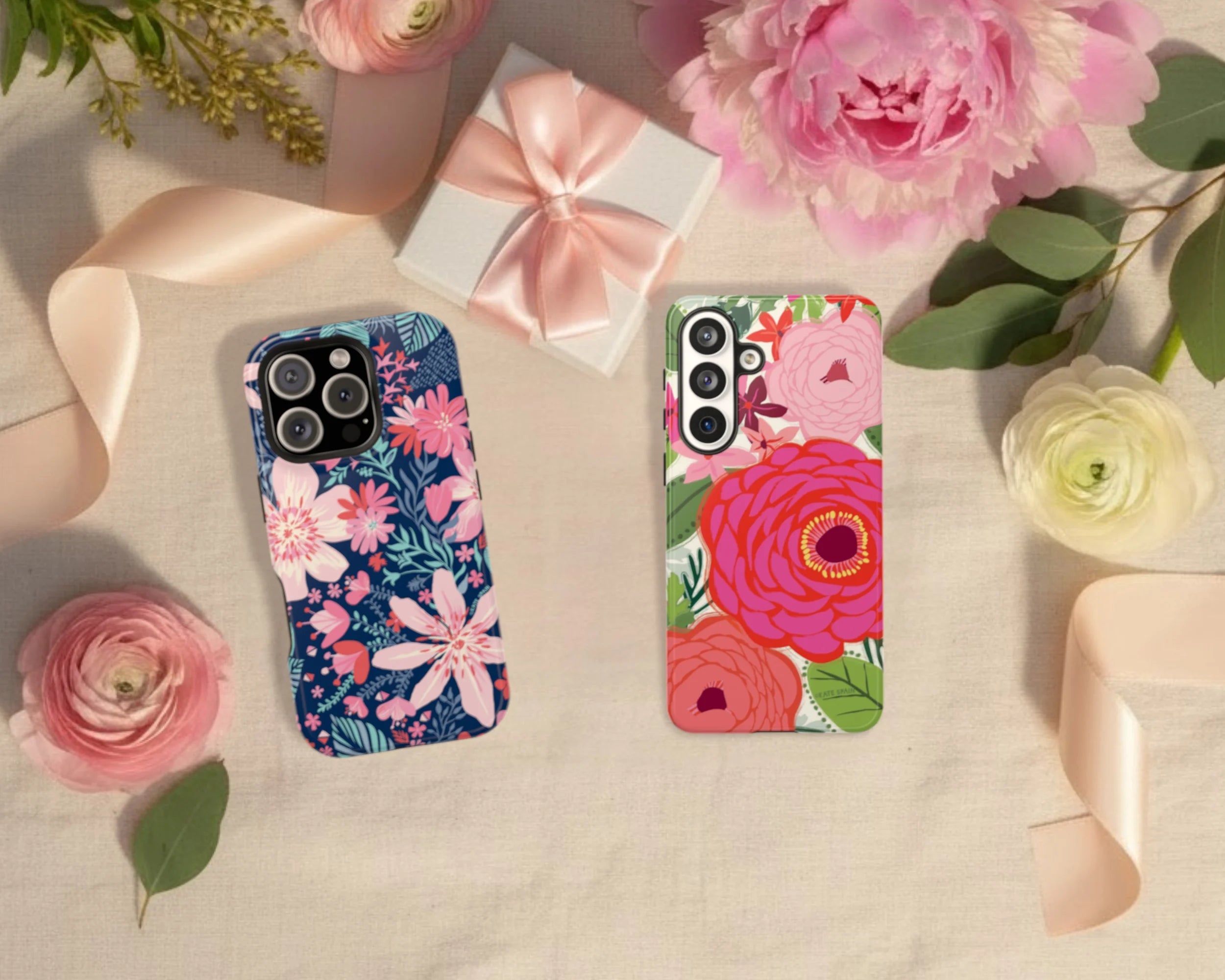 Two floral phone cases on a surface with flowers and ribbons.