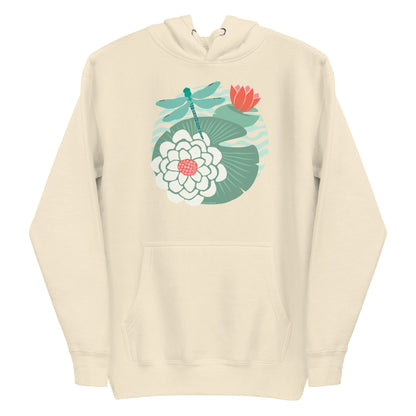 Illustrated dragonfly hovering over a green lily pad with pink and white water lily flowers on a rippled circular pond, printed on a soft premium off-white bone colored hoodie sweatshirt.