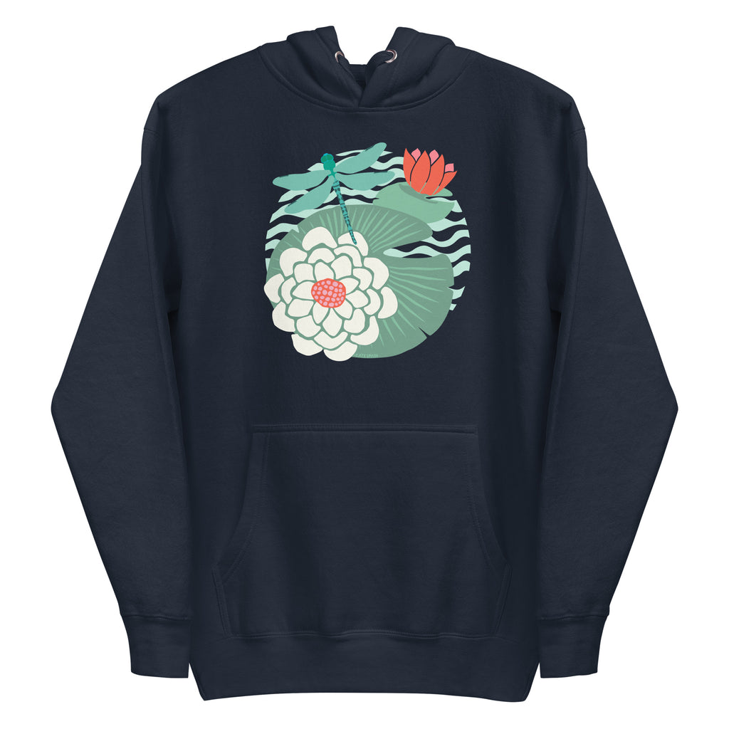 Illustrated dragonfly hovering over a green lily pad with pink and white water lily flowers on a rippled circular pond, printed on a soft premium navy blue colored hoodie sweatshirt.