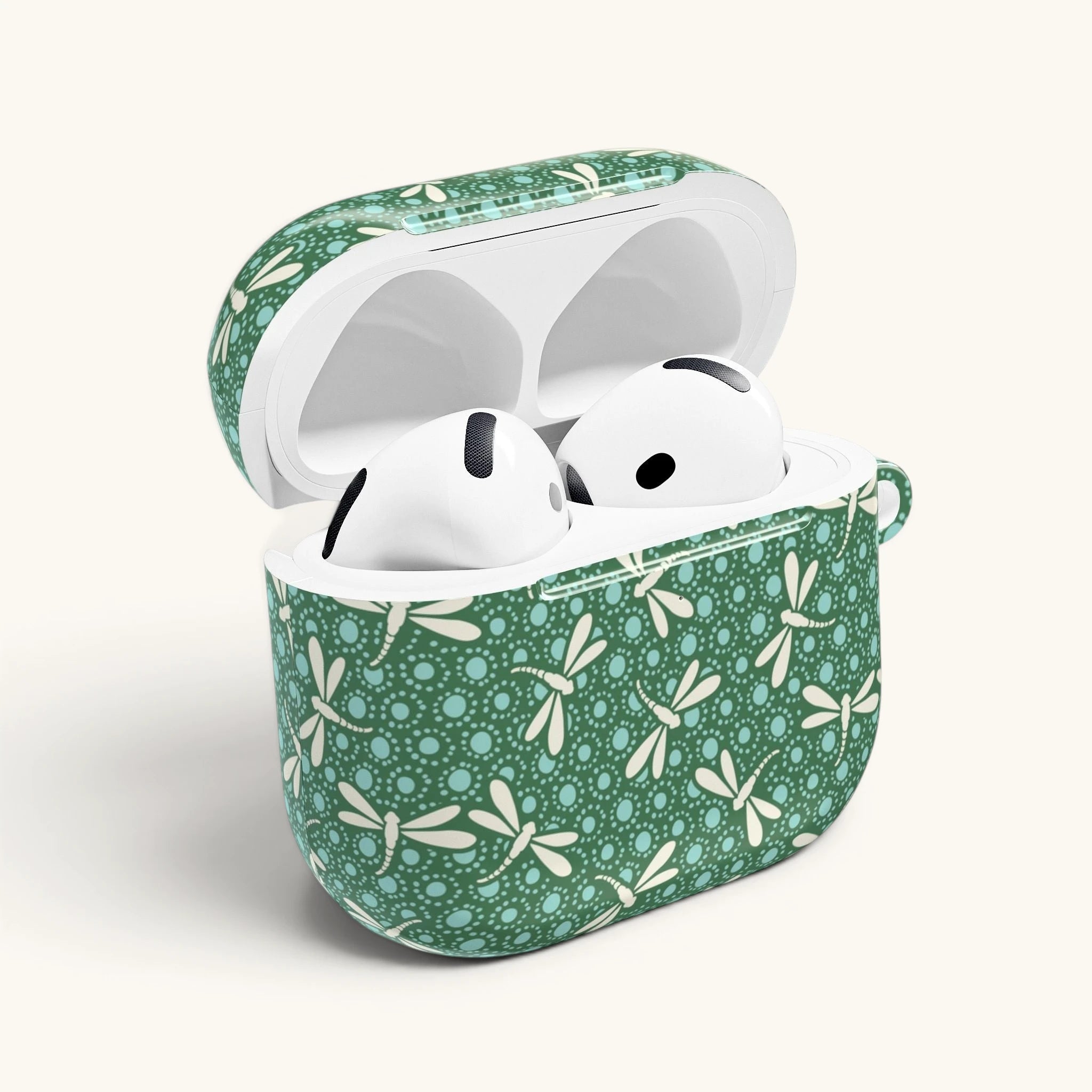 AirPods Gen 4 case with open lid, showing inside white ear buds – Glossy | cream dragonflies in flight on deep emerald green ground with aqua dot medallions