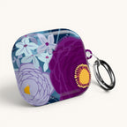 Floriori Bloomerie Violet AirPods Pro case with a floral print in deep violet, plum, and light blue. Features a glossy finish and carabiner clip.