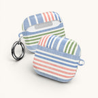 floriori Cabana Stripe Pastel AirPods Case with blue, coral, and sage green stripes and a chambray texture. Includes carabiner.