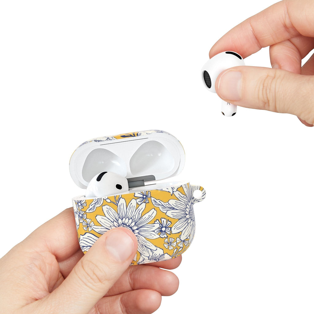 floriori Jardin Yellow AirPods case featuring a white hand drawn botanical toile print on a golden yellow glossy polycarbonate shell. Showing scale.