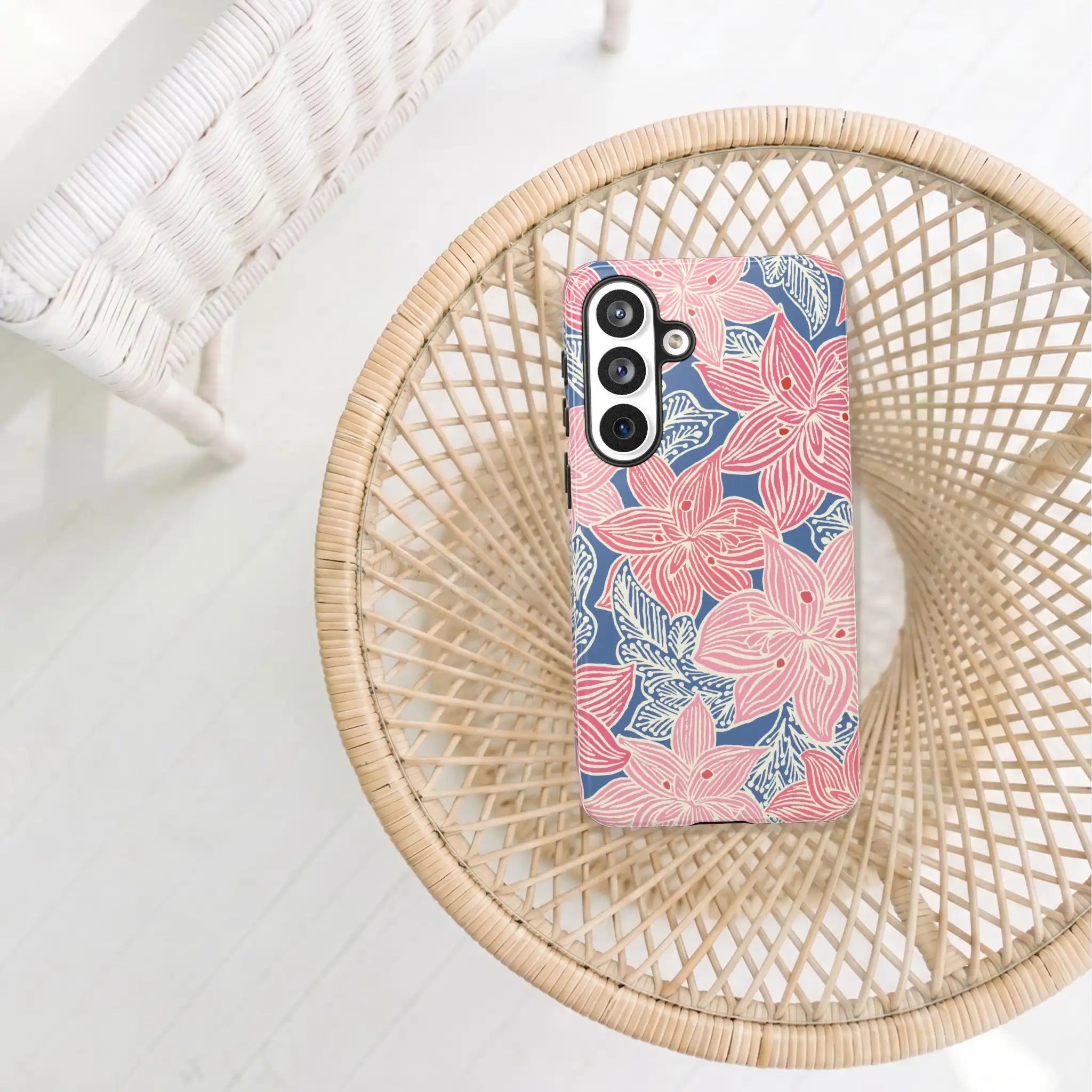 Phone case with pink floral design on a woven surface