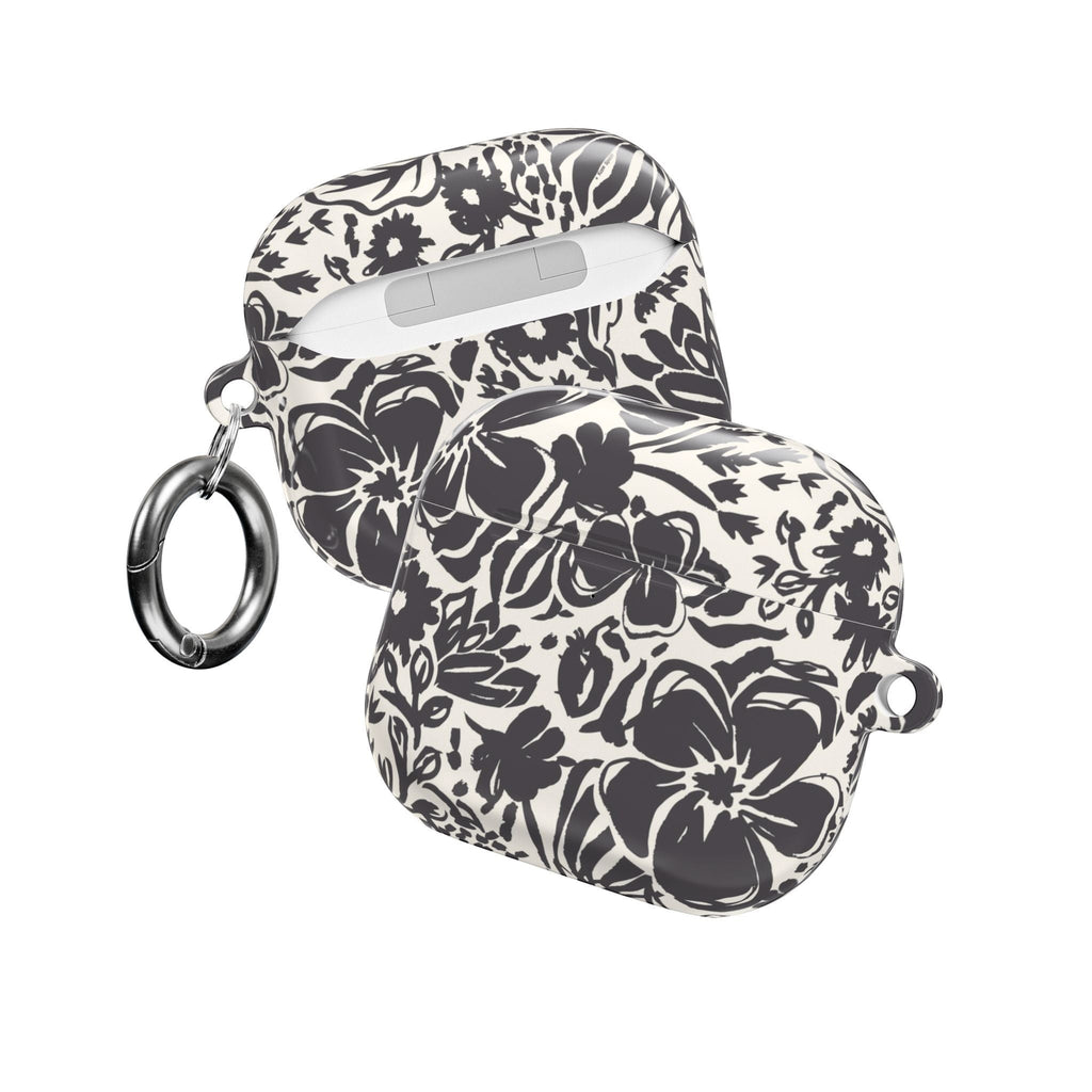 floriori AirPods case with sophisticated and energetic hand painted flower silhouettes. black floral on a cream glossy background. front and back view