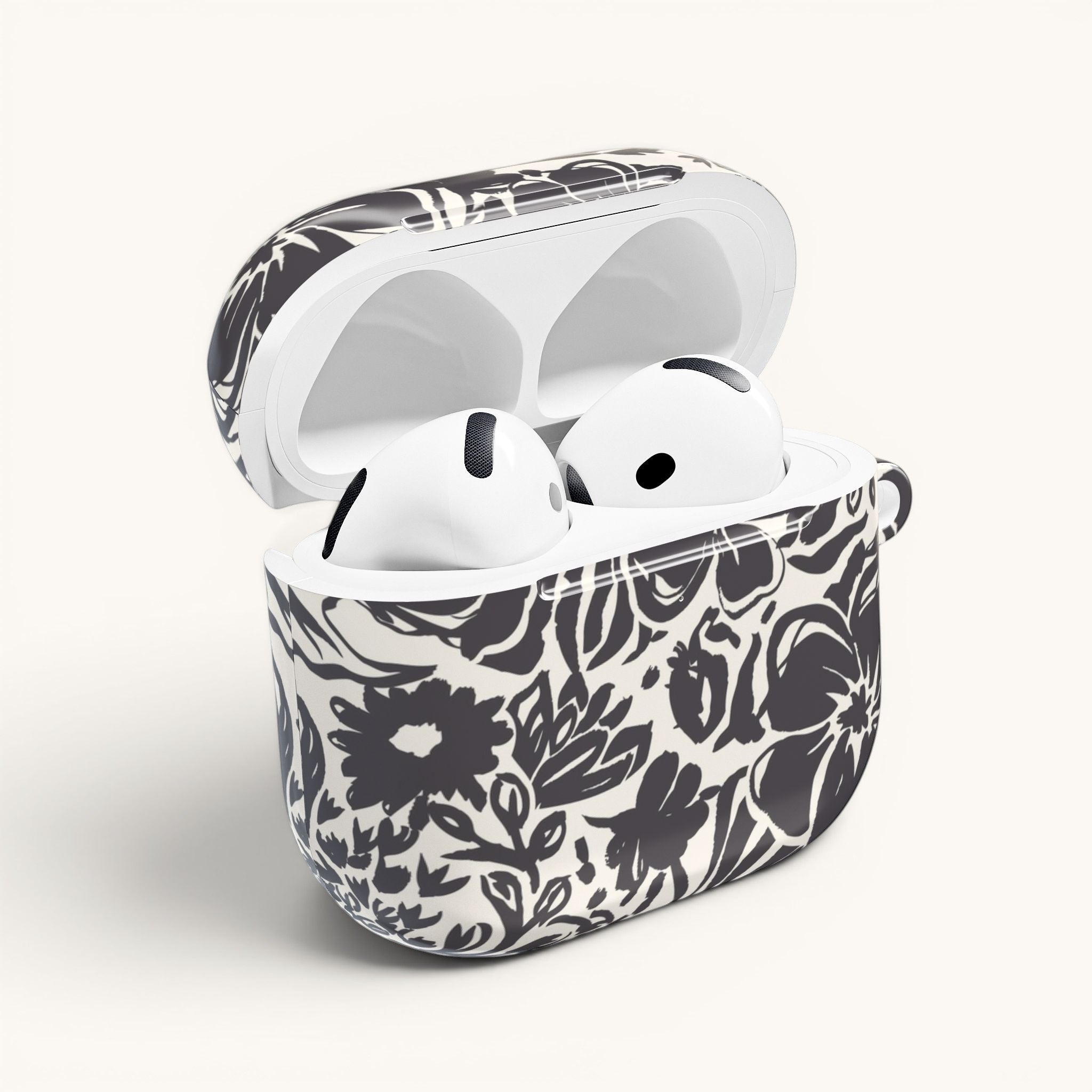 floriori AirPods case with sophisticated and energetic hand painted flower silhouettes. black floral on a cream glossy background. open with earbuds