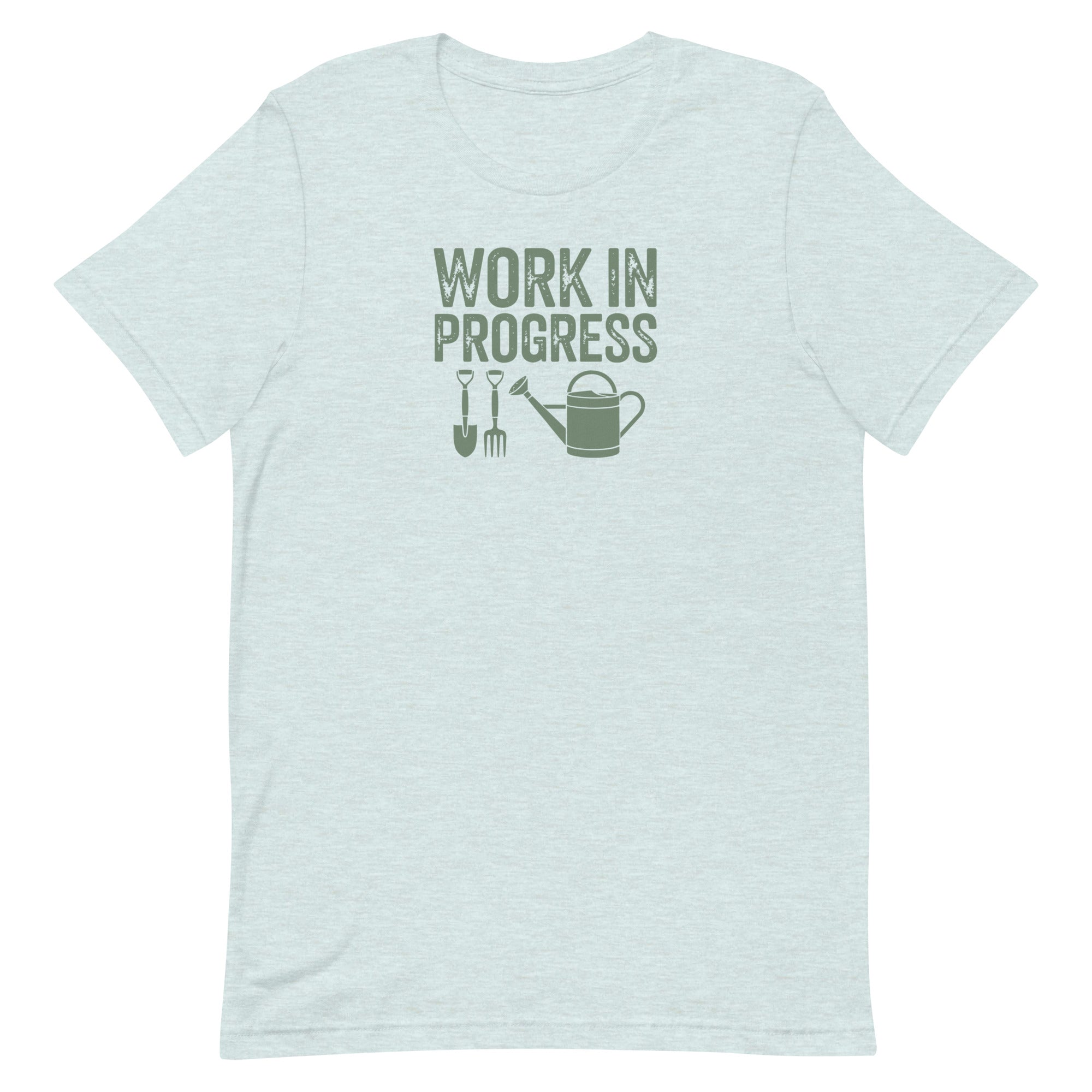 “Work in Progress” gardening graphic with shovel, pitchfork, and watering can printed in sage green on a soft heather ice blue colored crewneck t-shirt.