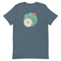Illustrated dragonfly hovering over a green lily pad with pink and white water lily flowers on a calm pond, printed on a soft gray-blue colored premium quality crewneck t-shirt.