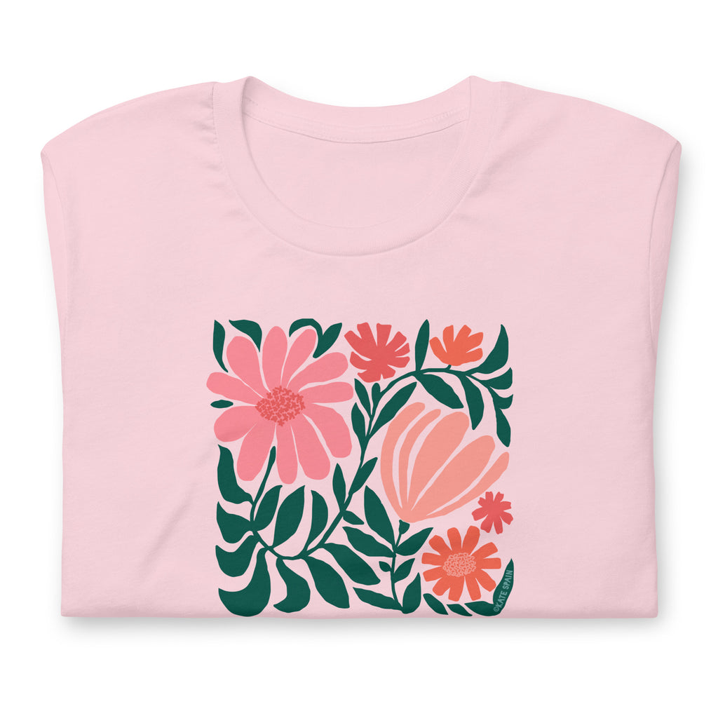 Minimalist floral graphic design with modern botanical illustrations printed on an pale soft pink colored premium crewneck tshirt. Shown folded for scale.